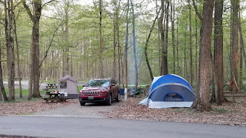 Simple campsite setup with a Jeep, tents and cooking area during a road trip around Lake Michigan