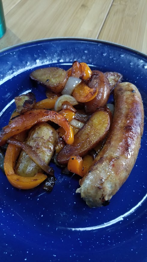 Sausages with roasted potatoes, onions and bell peppers, cooked as a simple one-pan meal while traveling.